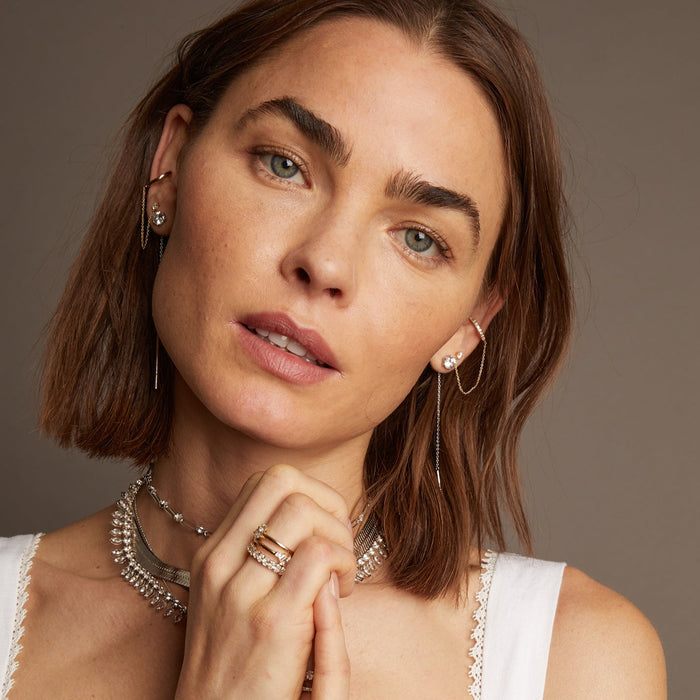 Model. Woman wearing various chains and earrings