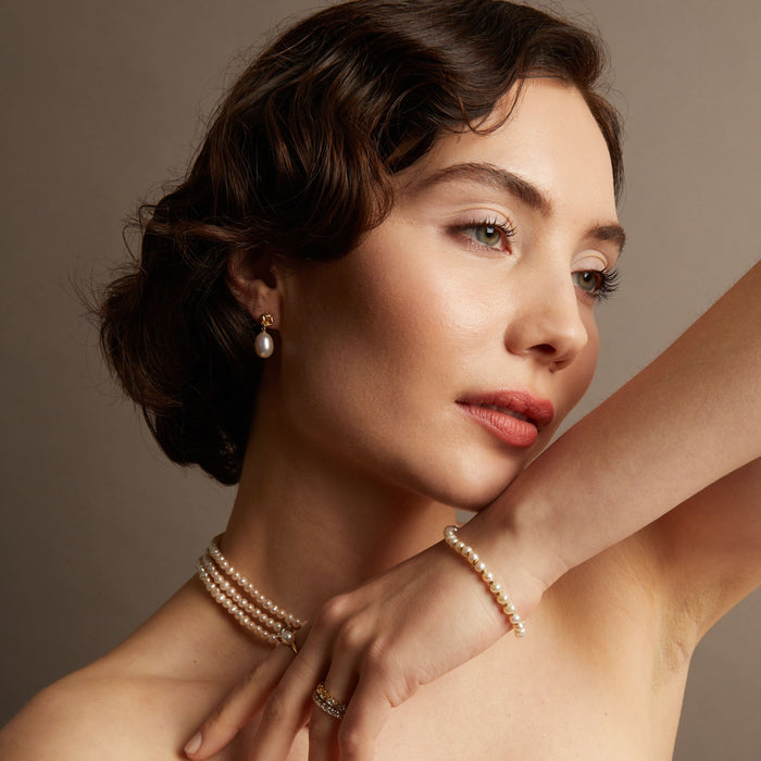 Model. Woman wearing pearl jewelry against a neutral background