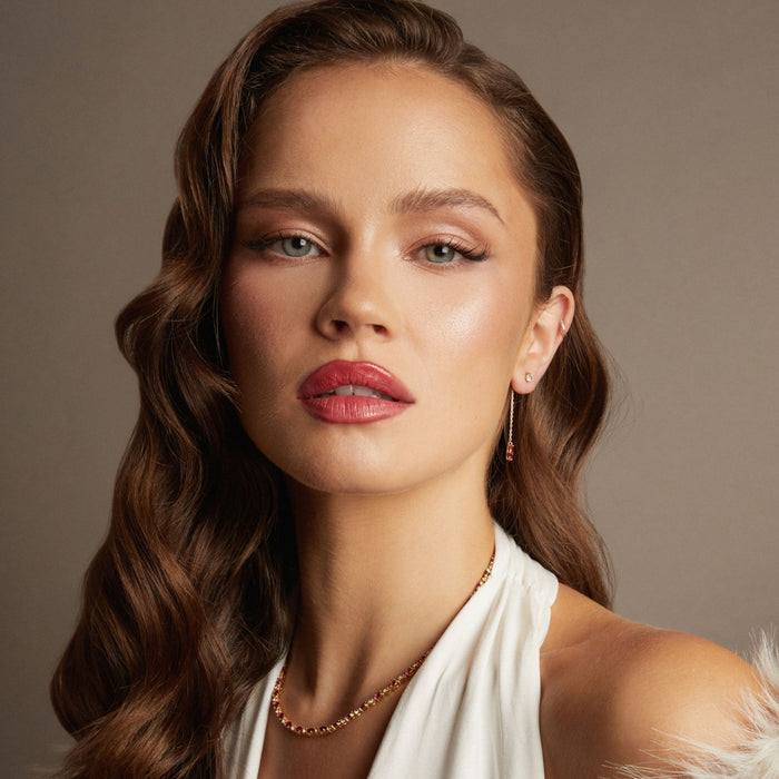 Model. Woman with styled hair and makeup against a neutral background