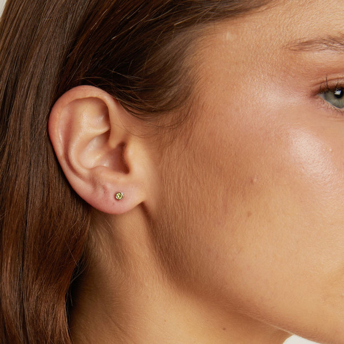 Model. Close-up of a person wearing a small earring near their ear.