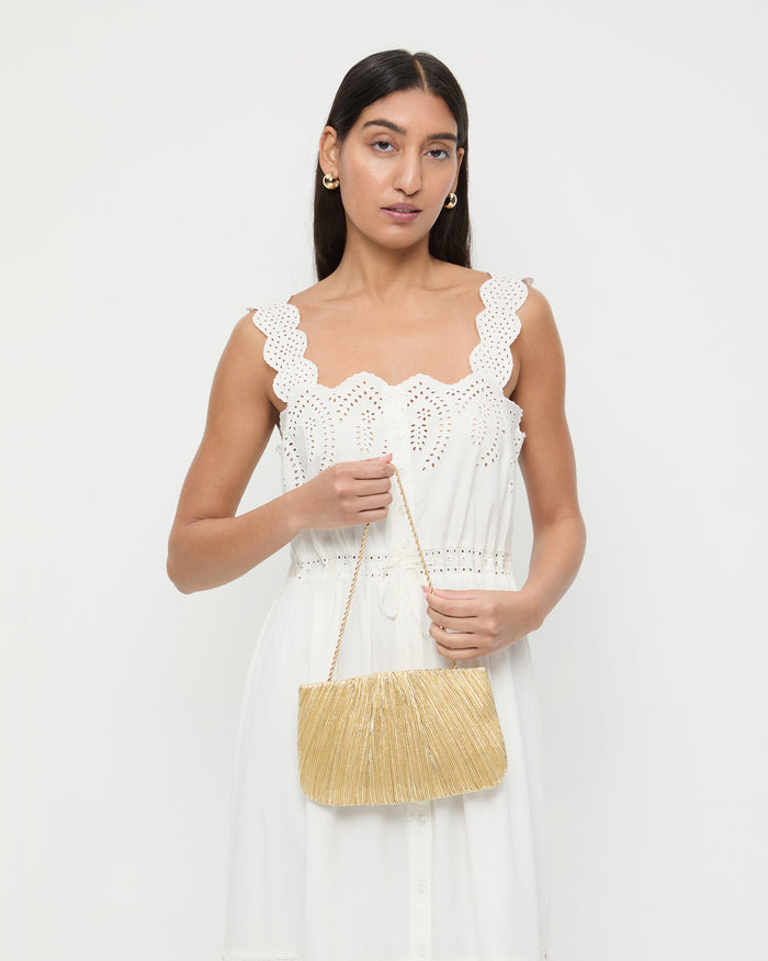 Brit Gold Lamé Pleated Clutch in pleated gold lamé and Sandra Dress in white cotton.