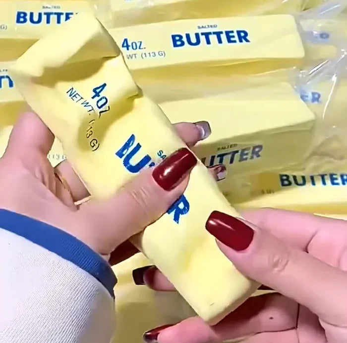 Hands holding a block of butter with 'Butter' packaging in the background