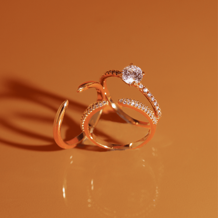 Flatlay Model three gold rings resting on an orange background