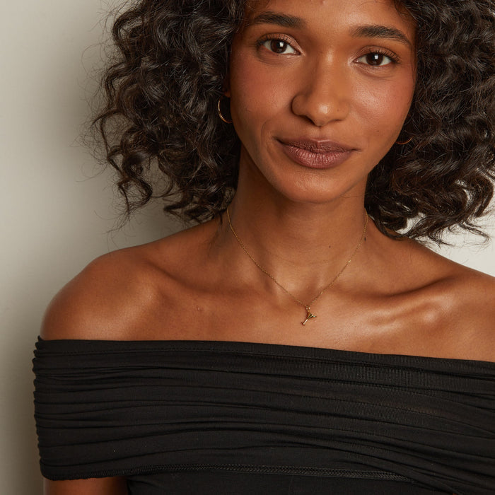 Model. Woman wearing a black off-shoulder top against a plain background