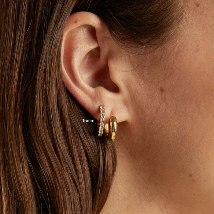 Model. Close-up of an ear wearing gold hoop earrings with a measurement label.