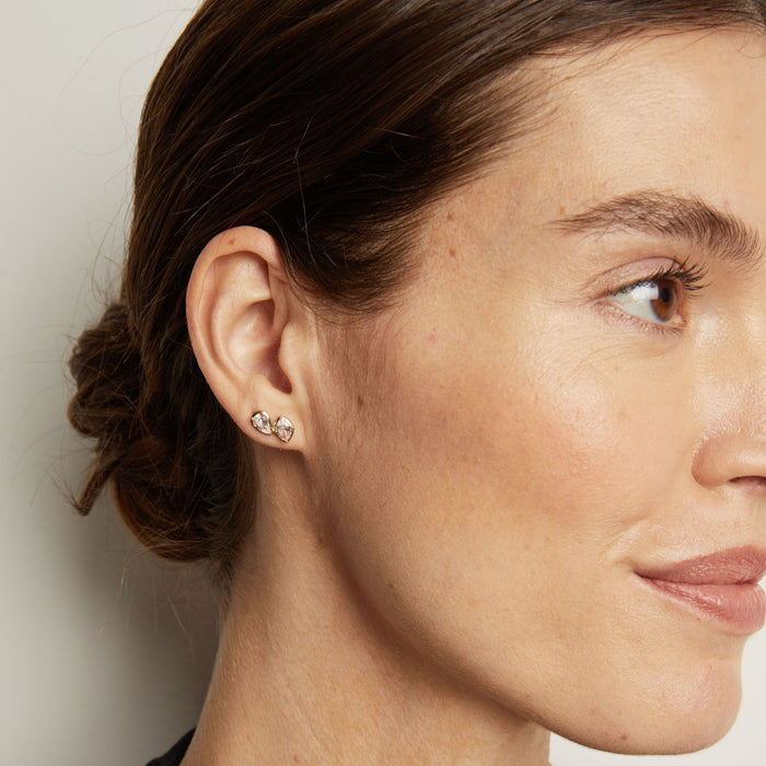 Model. Close-up of a woman wearing diamond earrings with a neutral background