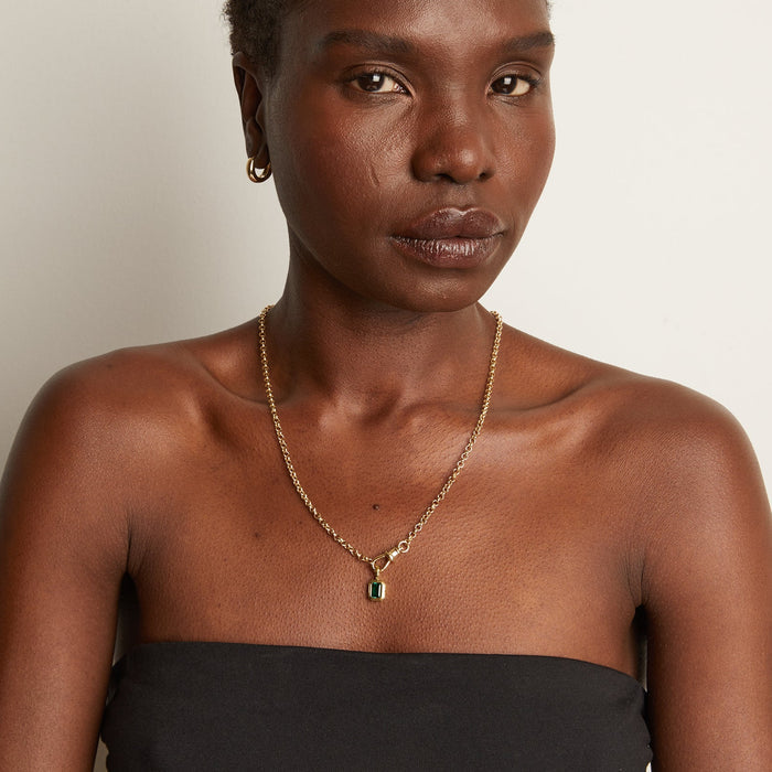 Model Close-up of a woman wearing a gold chain necklace with a ring clasp and a green rectangular pendant.