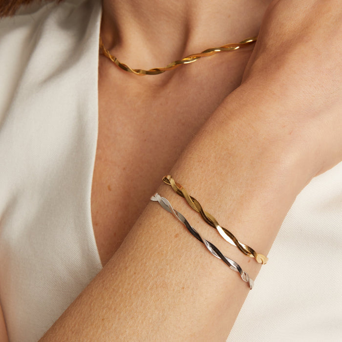 Model. A person wearing a yellow gold herringbone twist bracelet on their wrist.