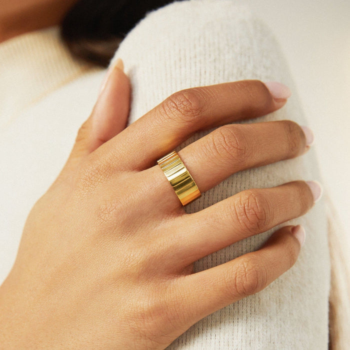 Lifestyle Model. A close-up lifestyle shot of a woman wearing a thick gold band ring.