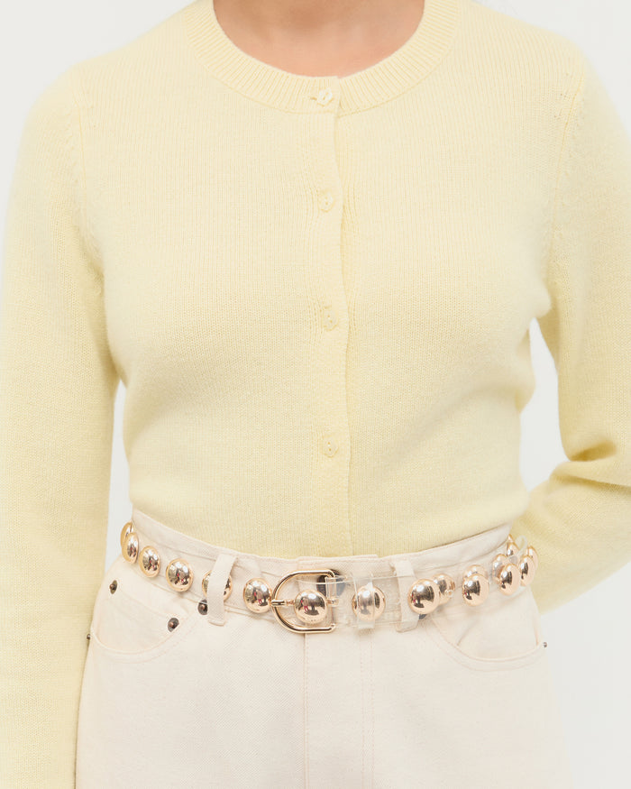 Issa Clear/Champagne Studded Belt in clear plastic with champagne stud accents, Tucker Cashmere Cardigan in butter yellow cashmere, and Winona Denim Pant in natural denim.