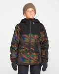 A boy stands against a plain white background, looking directly at the camera, dressed in a brown beanie, black gloves, and the Volcom Kids’ Youth Stone.91 Insulated Jacket—a colorful patterned youth snow jacket featuring recycled insulation and a black top section.