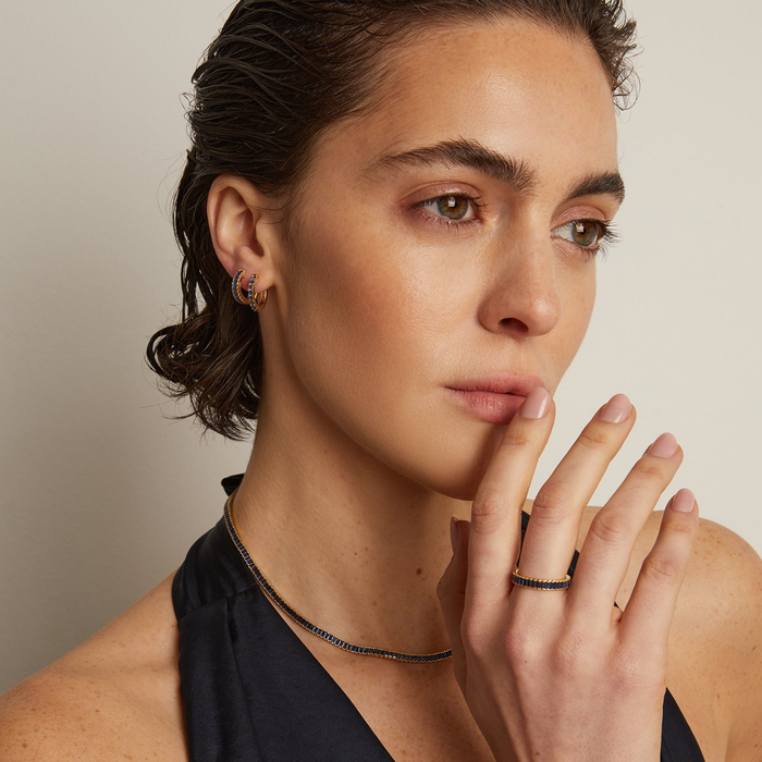 Model.  woman wearing two blue stone earrings on blank background