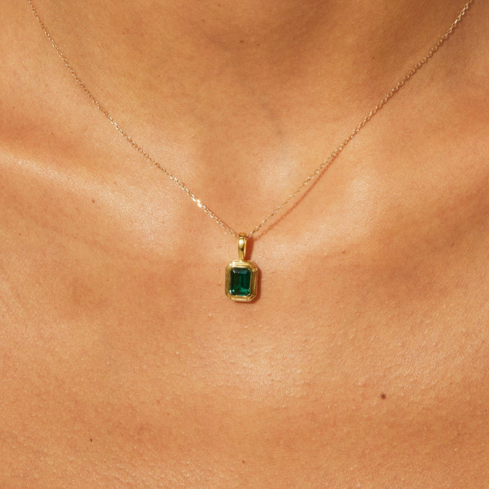 Lifestyle Model close up of a green stone on a gold chain
