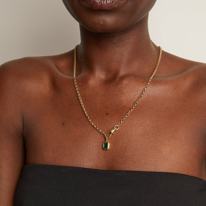 Model woman wearing a chain with a green stone