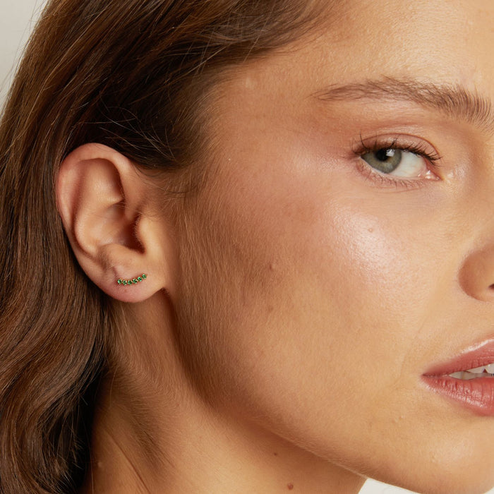 Model. Close-up of a woman's ear wearing a small earring with a blurred background