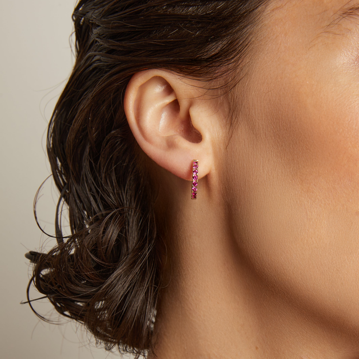 Model. Close up of woman wearing pink tone hoop earring