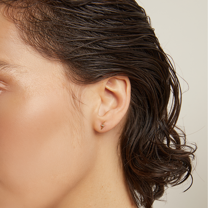 Model. Woman with wet hair wearing a brown top against a neutral background