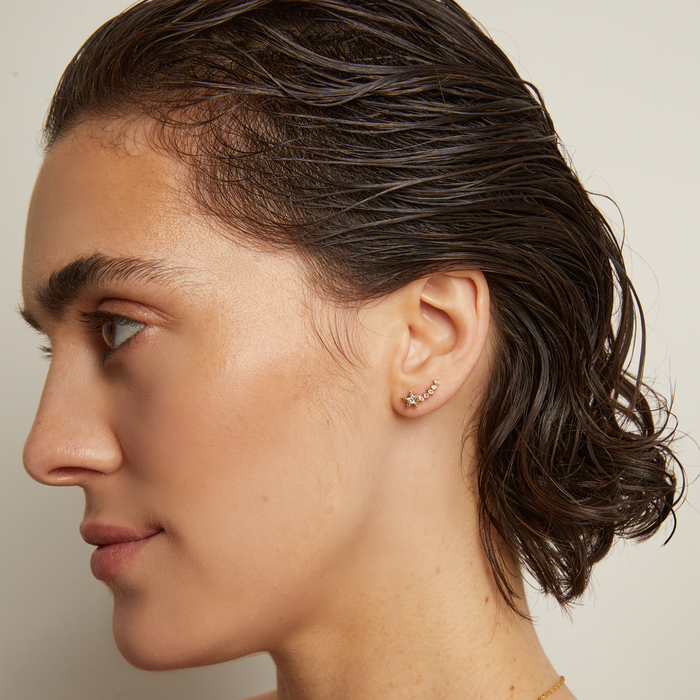 Close-up of a person wearing stud earrings.