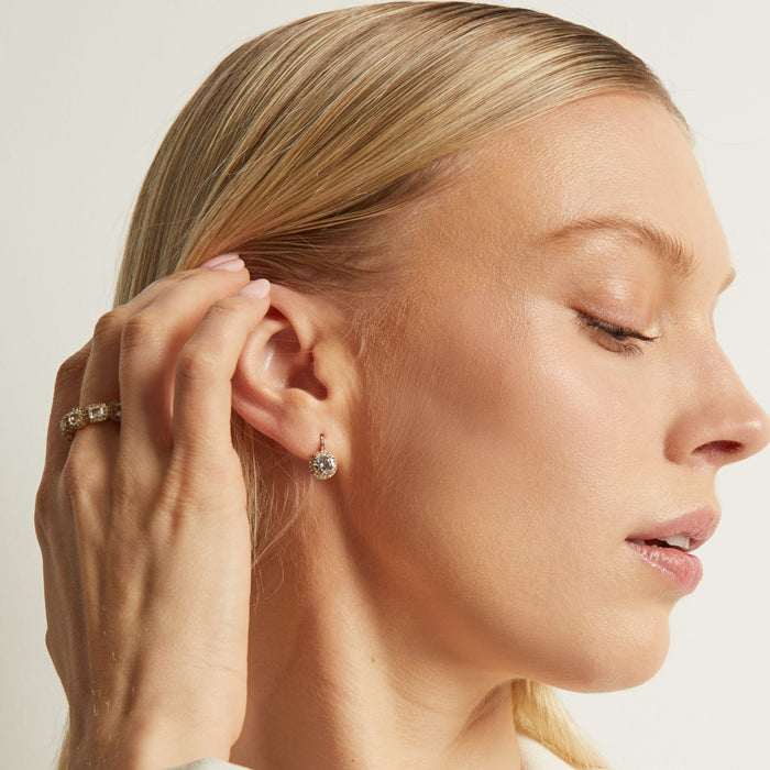 Model. Woman wearing a diamond earring with a neutral background