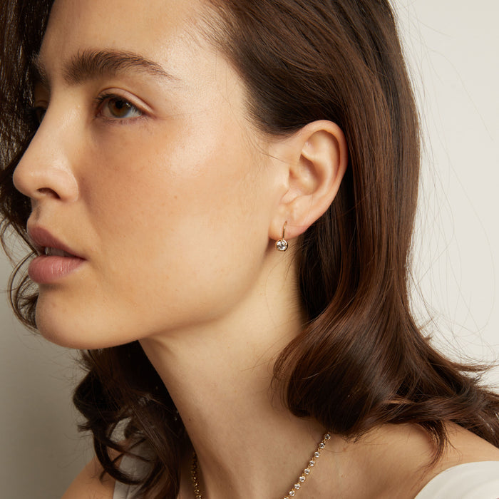 Model. Close-up of a woman wearing earrings with a neutral background