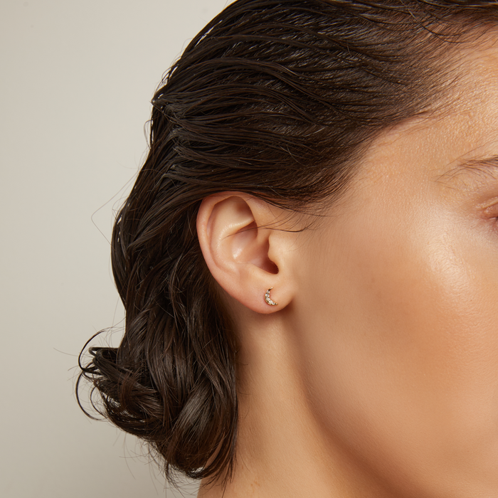 Model. Woman wearing gold necklaces with a neutral background