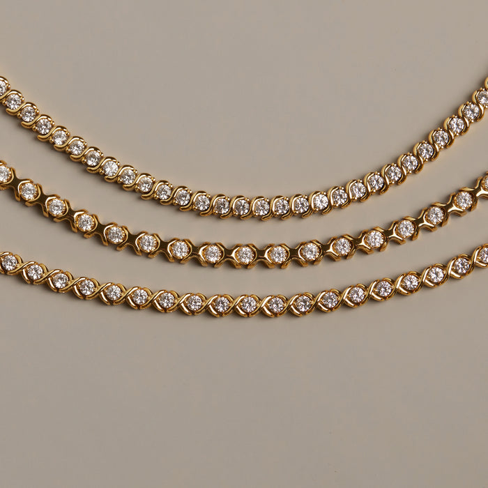 Flatlay Model. Gold necklaces with diamond accents on a beige background