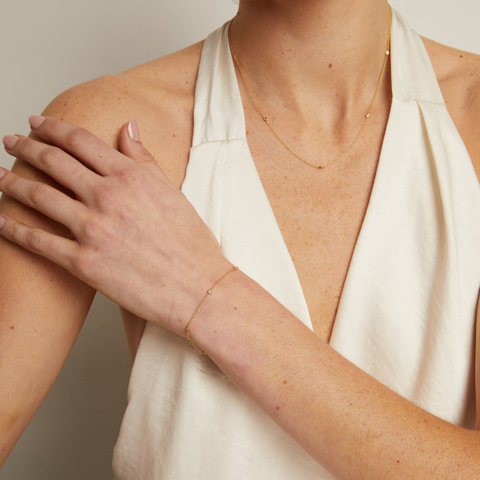 Model. Woman wearing a white halter neck top with a neutral background