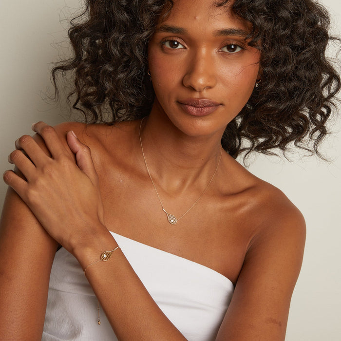 Model. Woman wearing gold jewelry against a neutral background