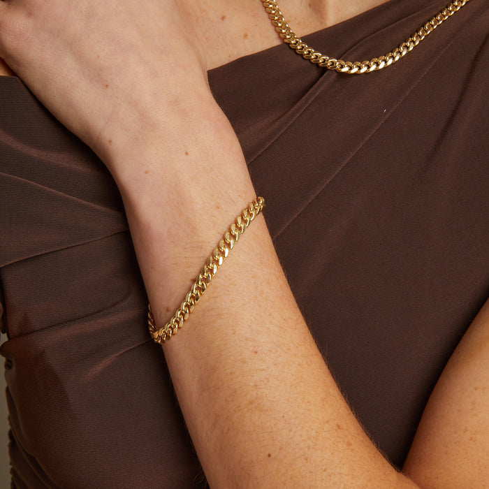 Model. close up of woman wearing gold chain bracelet