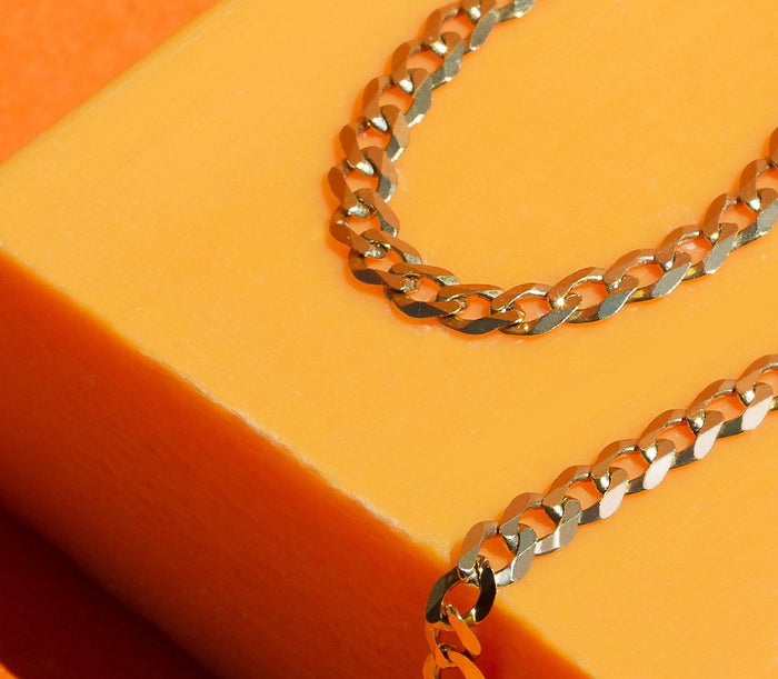 Flatlay Model. Gold chain bracelet on yellow background