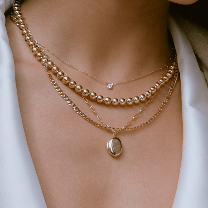 Lifestyle Model. Close up of woman wearing stacked necklaces