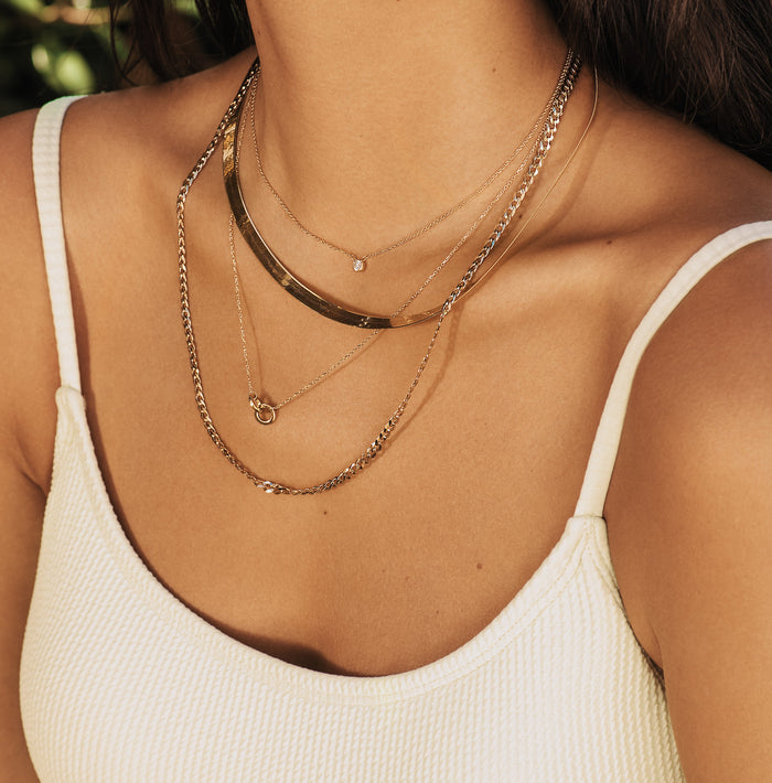 Lifestyle Model. Close up of woman wearing stacked necklaces
