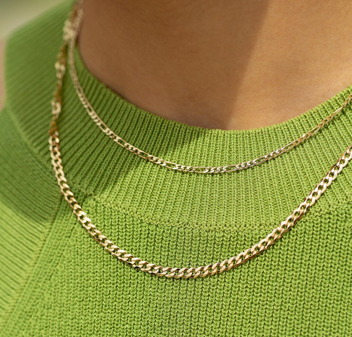 Lifestyle Model. Close up of woman wearing stacked gold chain necklaces