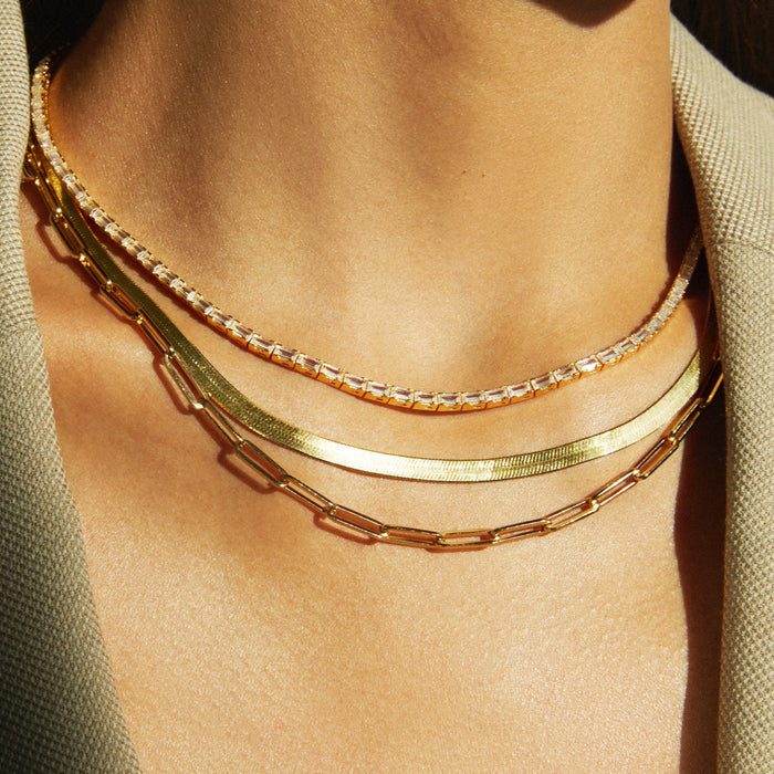 Lifestyle Model. Close up of woman wearing two chain necklaces and a diamond tennis necklace