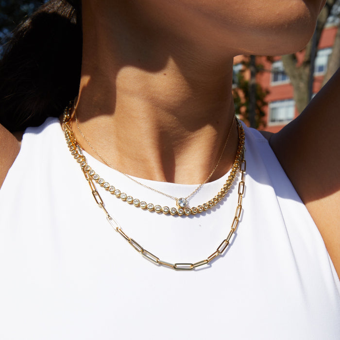 Lifestyle Model. Close up of woman wearing three necklaces with white tank top