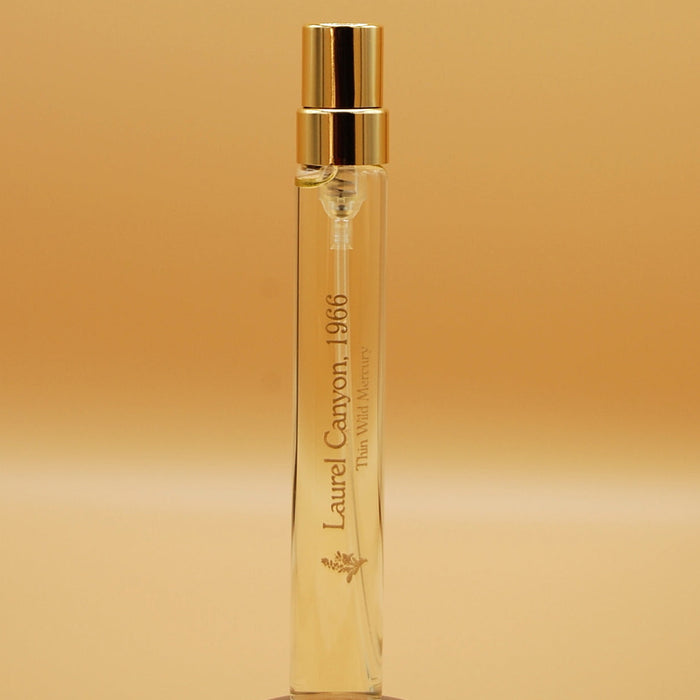 A clear glass 8ml travel sprayer with a gold cap labeled 'Laurel Canyon , 1966'