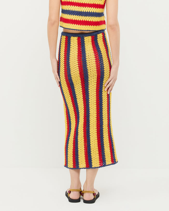 Lela Crochet Skirt in yellow, red, and navy striped hand-crocheted cotton, Prescott Crochet Top in yellow, red, and navy striped hand-crocheted cotton, and Mika Maroon/Yellow Sport Sandal.