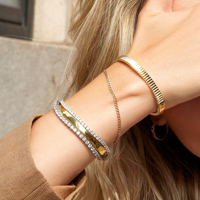 Lifestyle Model. Close up of woman wearing stacked gold and diamond bracelets