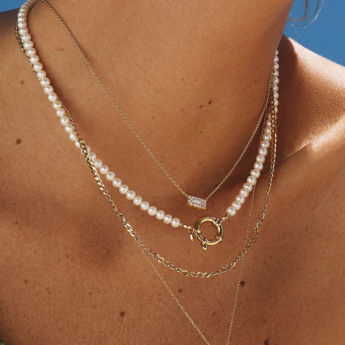 Lifestyle Model. Close up of a woman wearing stacked necklaces