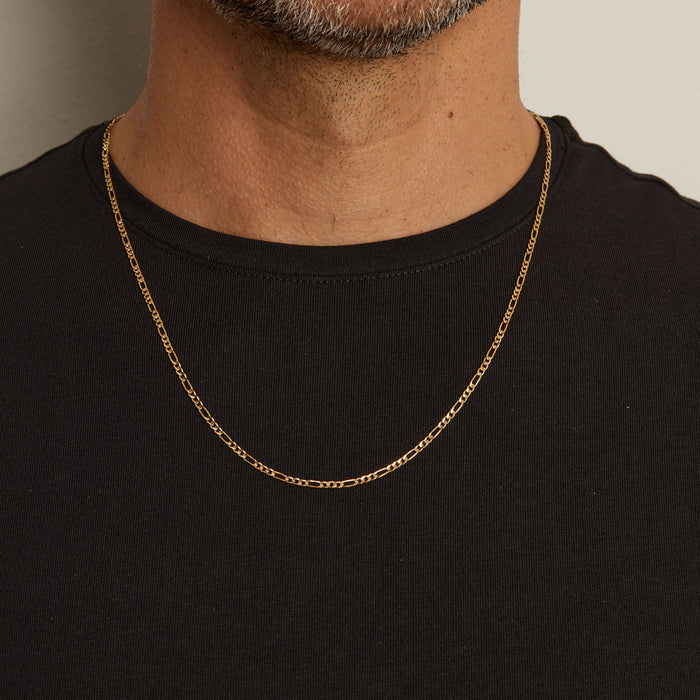 Model. Close up of man wearing gold chain necklace over a black t shirt