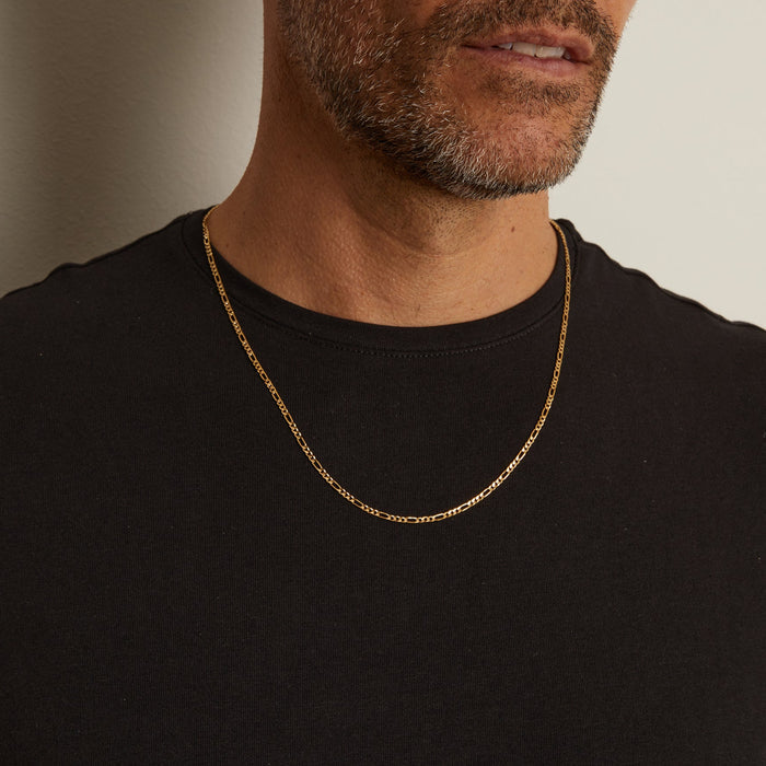 Model. Close up of man wearing gold chain necklace over a black t shirt