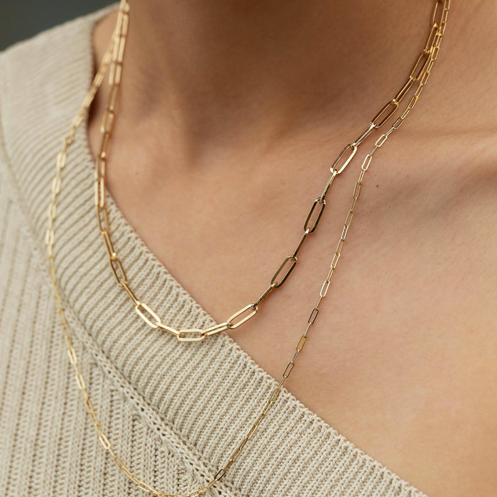 Flatlay Model. Close up of woman wearing two chain necklaces with beige sweater