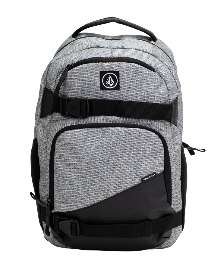 A Volcom Men's Grindstone Skate Backpack in gray and black, featuring two front zippered pockets, black adjustable straps with buckles, a padded laptop sleeve, and a top handle, displayed against a plain white background.