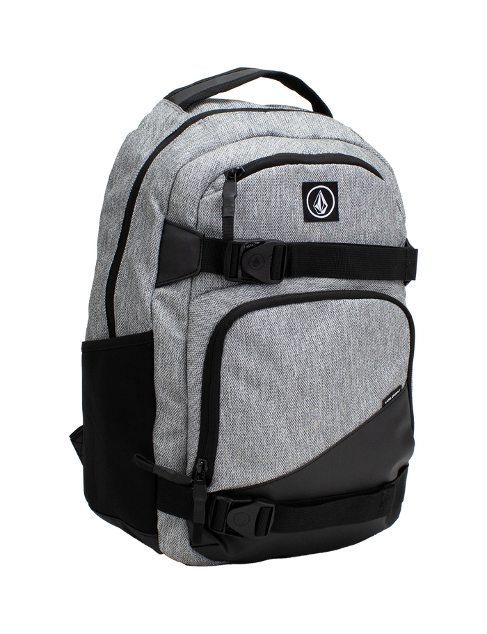 Volcom Men's Grindstone Skate Backpack in gray and black features multiple zippered compartments, side pockets, and a top handle. This backpack includes a logo patch on the front, adjustable straps, and a padded laptop sleeve for added convenience.