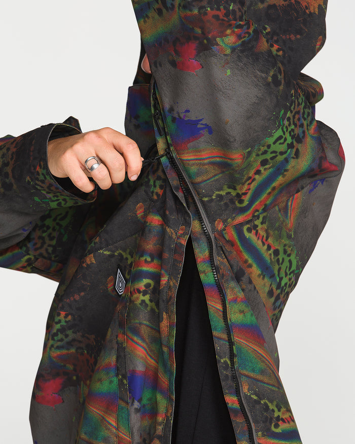 A person, visible from the torso with one ringed hand, zips up the Volcom Men’s Hossegor 20K Pullover in a vibrant abstract pattern, highlighting its recycled V-Science shell against a plain background.