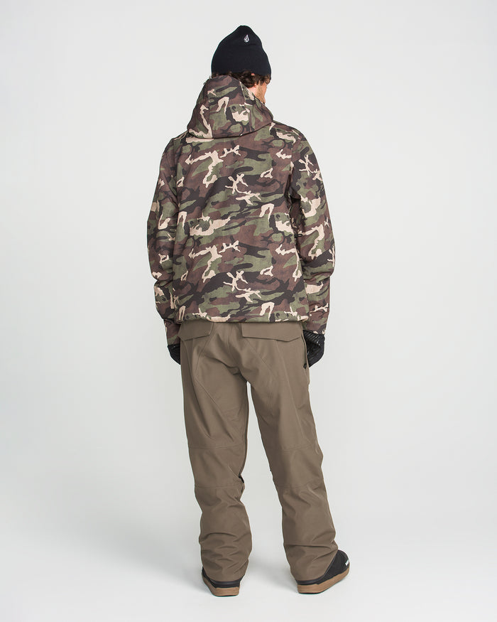 A person stands facing away from the camera against a plain white background, wearing a camo jacket, brown pants inspired by the rugged style of Volcom’s Men’s Roan Bib, black gloves, and a black beanie.