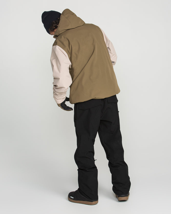 A person is seen from behind, standing against a plain white background, wearing the Volcom Men’s Roan Bib paired with a brown hooded jacket, gloves, and a black beanie.