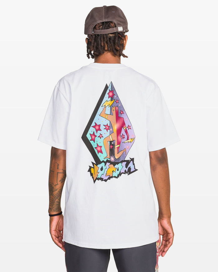 A man, seen from behind, wears a Volcom Men's Star Shields Featured Artist Exp Short Sleeve Tee—100% cotton with a colorful abstract star-and-shape graphic on the back—and a dark baseball cap.