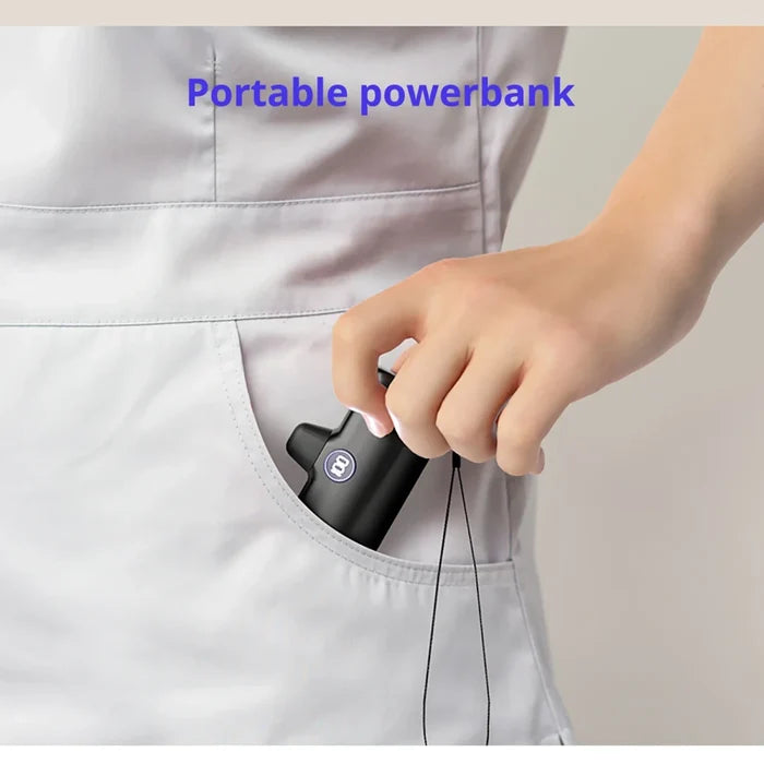 A hand inserting a black portable power bank into the pocket of a light gray uniform, with the text 'Portable powerbank' overlaid at the top.