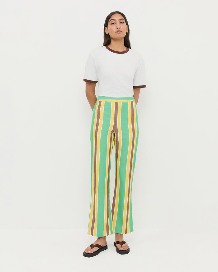 Pasha Trouser in green/yellow/brown striped cotton-linen, Harly Tee in white cotton, and Chase Brown Flip Flop.